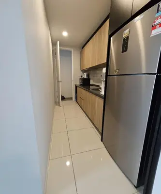 a kitchen with a refrigerator and a tile floor at The Signature Suites at Robertson Bukit Bintang in Kuala Lumpur