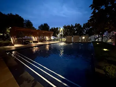 a large swimming pool at night with a pavilion at M Vertica Residence by Dynasty in Kuala Lumpur