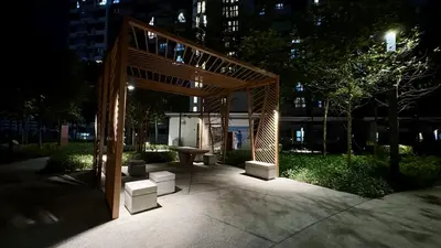 a pavilion with a bench in a park at night at M Vertica Residence by Dynasty in Kuala Lumpur