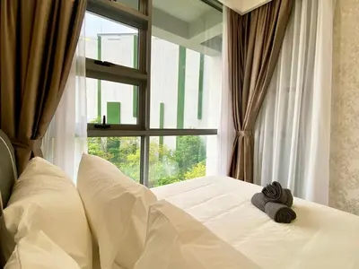 a bed with two towels on it in front of a window at The Loft Living Suites at Robertson Residences in Kuala Lumpur