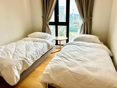 two beds in a room with a window at KL Central 32 Floor KLCC View in Kuala Lumpur