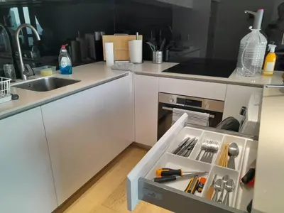 a kitchen with white cabinets and a drawer withrenches at Star Residences One in Kuala Lumpur
