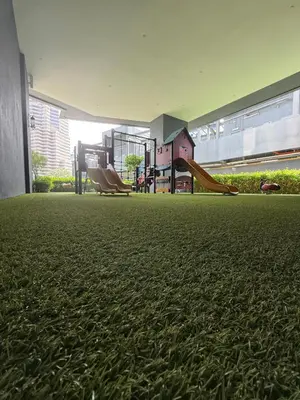a room with a playground with a slide and chairs at Star Residences One in Kuala Lumpur