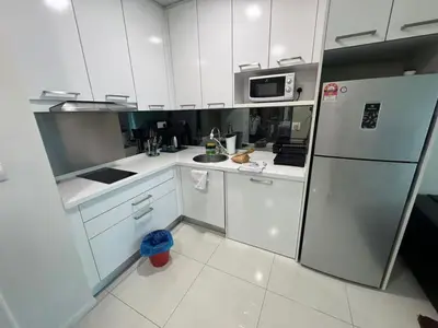 a kitchen with white cabinets and a refrigerator at Summer Suites KLCC Apartments by Soulasia in Kuala Lumpur