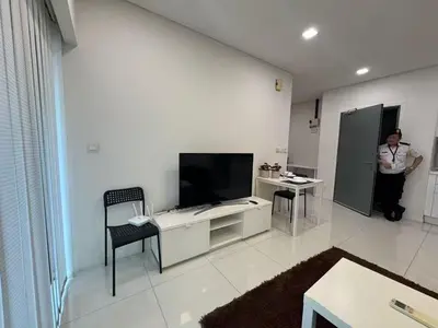 a man standing in a living room with a television at Summer Suites KLCC Apartments by Soulasia in Kuala Lumpur