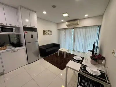 a kitchen and living room with a refrigerator and a couch at Summer Suites KLCC Apartments by Soulasia in Kuala Lumpur
