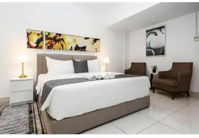a bedroom with a large bed and a chair at Bmc Homez Suite 3towers in Kuala Lumpur