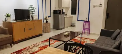 a living room with a tv and a couch and a table at Bmc Homez Suite 3towers in Kuala Lumpur