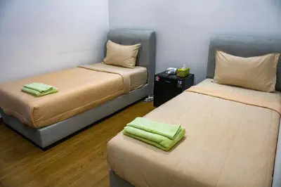 two beds in a room with green towels on them at Entire Apartment in Kuala Lumpur, Infinity Pool!! in Kuala Lumpur