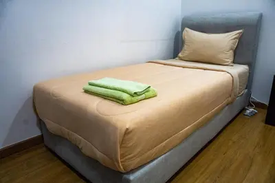 a bed with a green towel on top of it at Entire Apartment in Kuala Lumpur, Infinity Pool!! in Kuala Lumpur