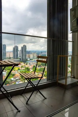 a chair and a table in a room with a window at Entire Apartment in Kuala Lumpur, Infinity Pool!! in Kuala Lumpur