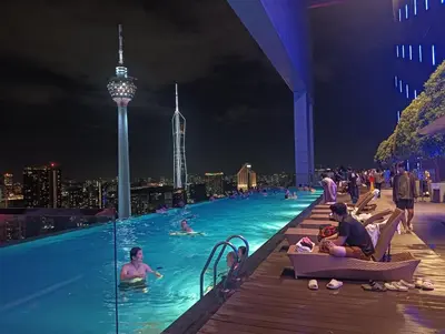 a group of people in a swimming pool at night at KLCC Sky villa Suites Platinum by MiM in Kuala Lumpur