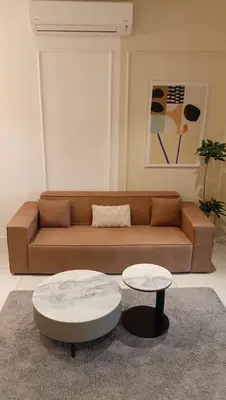 a living room with a brown couch and a table at Quill Residence- City View Condo by Azmila in Kuala Lumpur