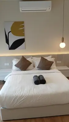 a white bed with two pairs of shoes on it at Quill Residence- City View Condo by Azmila in Kuala Lumpur