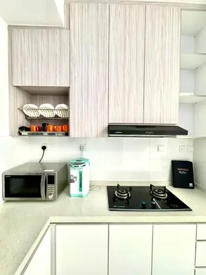 a kitchen with a stove and a microwave at 3Room 5 Pax stay in Mont Kiara in Kuala Lumpur