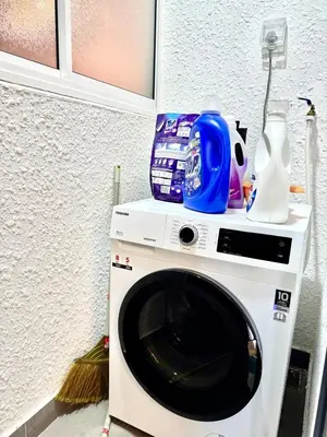 a washing machine in a room with a detergents at 3Room 5 Pax stay in Mont Kiara in Kuala Lumpur