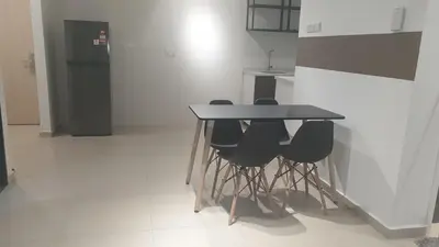 a table and chairs in a kitchen with a refrigerator at 10 Pax stay in Kl Area in Kuala Lumpur
