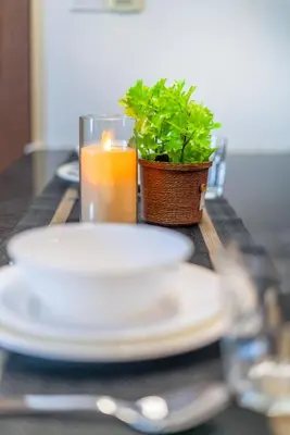 a table with plates and a candle and a potted plant at Dua Sentral Kuala Lumpur near KL Sentral in Kuala Lumpur
