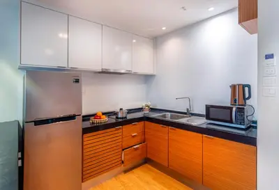 a kitchen with wooden cabinets and a stainless steel refrigerator at Dua Sentral Kuala Lumpur near KL Sentral in Kuala Lumpur
