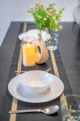 a table with two plates and a candle and flowers at Dua Sentral Kuala Lumpur near KL Sentral in Kuala Lumpur