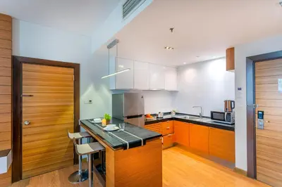 a kitchen with wooden cabinets and a black counter top at Dua Sentral Kuala Lumpur near KL Sentral in Kuala Lumpur