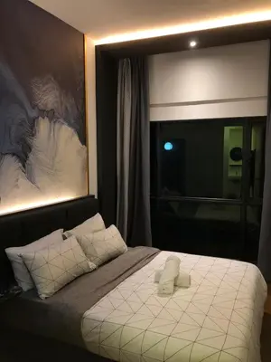 a bedroom with a bed with a large painting on the wall at Cozy Stay in KLCC\u5409\u9686\u73bb in Kuala Lumpur