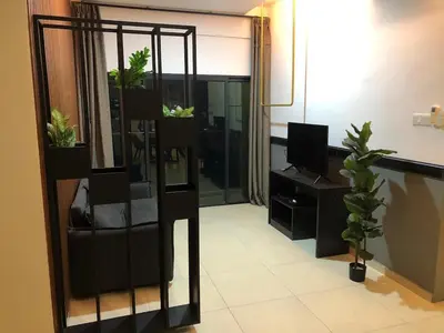 a living room with potted plants and a television at Cozy Stay in KLCC\u5409\u9686\u73bb in Kuala Lumpur