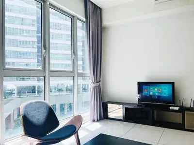 a living room with a tv and a large window at Regalia Residences And Suites By The Relaxstay in Kuala Lumpur