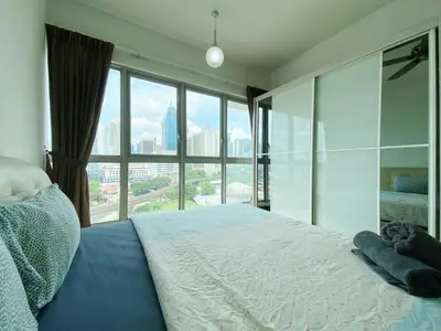 a bedroom with a bed and a large window at Regalia Residences And Suites By The Relaxstay in Kuala Lumpur