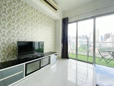 a living room with a tv and a large window at Regalia Residences And Suites By The Relaxstay in Kuala Lumpur