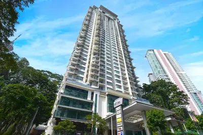 a tall white building in front of two tall buildings at Palette Bukit Bintang Formerly Suasana Suites in Kuala Lumpur