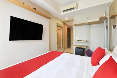 a bedroom with a bed with a tv on the wall at Palette Bukit Bintang Formerly Suasana Suites in Kuala Lumpur