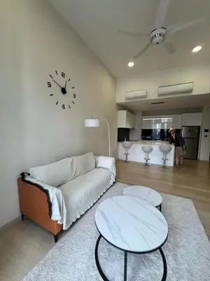 a living room with a couch and a clock on the wall at Star Residences One in Kuala Lumpur