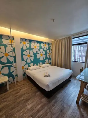 a bedroom with a bed with a flower patterned wall at V Garden Hotel by Minsu in Kuala Lumpur