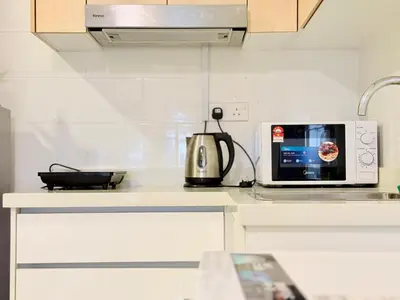 a kitchen with a microwave and a kettle on a counter at Arte Mont Kiara By The Relaxstay in Kuala Lumpur