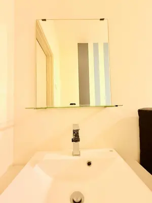 a bathroom with a white sink and a mirror at Arte Mont Kiara By The Relaxstay in Kuala Lumpur