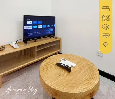 a living room with a table and a tv at Neu Suites By The Relaxstay in Kuala Lumpur