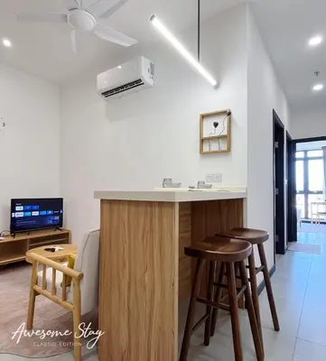a kitchen with a counter and stools in a room at Neu Suites By The Relaxstay in Kuala Lumpur