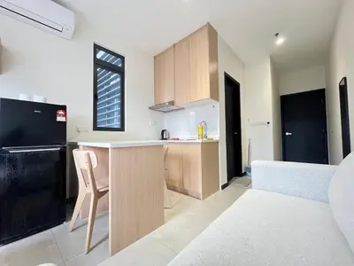 a kitchen with wooden cabinets and a counter top at Neu Suites By The Relaxstay in Kuala Lumpur