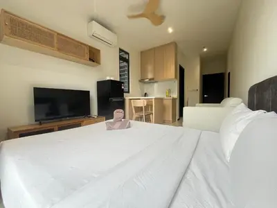 a bedroom with a large white bed and a television at Neu Suites By The Relaxstay in Kuala Lumpur
