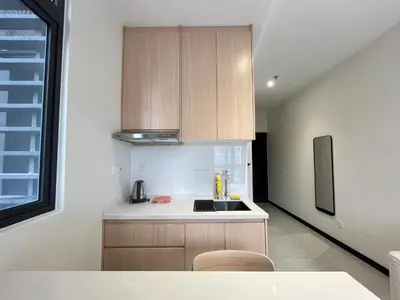 a kitchen with wooden cabinets and a sink at Neu Suites By The Relaxstay in Kuala Lumpur