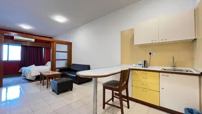 a kitchen and living room with a table and a bed at Cempaka Apartment by Easy Nap in Kuala Lumpur