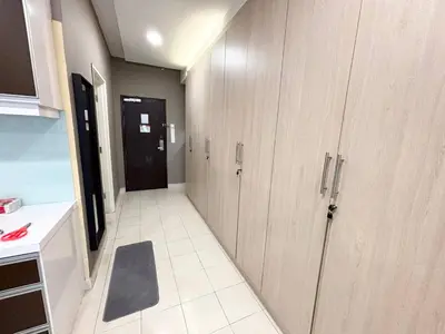 a hallway of a kitchen with wooden cabinets at Cempaka Apartment by Easy Nap in Kuala Lumpur