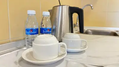 two bottles of water sitting on a kitchen counter at Cempaka Apartment by Easy Nap in Kuala Lumpur