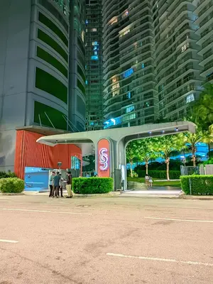 people standing at a gas station in front of tall buildings at Sky Suite KLCC By near klcc in Kuala Lumpur