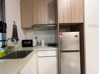 a small kitchen with a refrigerator and a sink at Regalia Residences and suits By Comfortcorner in Kuala Lumpur
