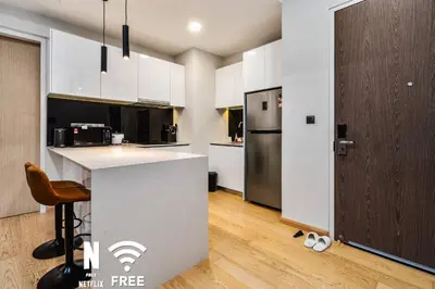 a kitchen with white cabinets and a black refrigerator at Comfy 1 BR unit 2 mins from KLCC in Kuala Lumpur