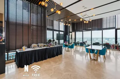a dining room with tables and chairs and windows at Comfy 1 BR unit 2 mins from KLCC in Kuala Lumpur