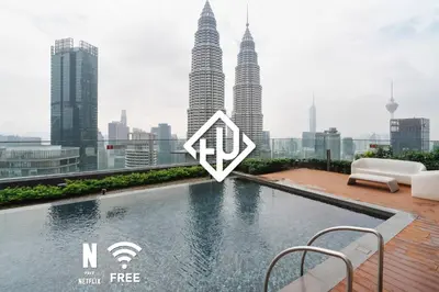 a swimming pool on the roof of a building with tall buildings at 1BR| Rooftop Twin Towers View l Near LRT in Kuala Lumpur
