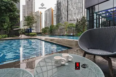 a table with cups on it next to a pool at Comfy 1BR with Twin Towers View in Kuala Lumpur